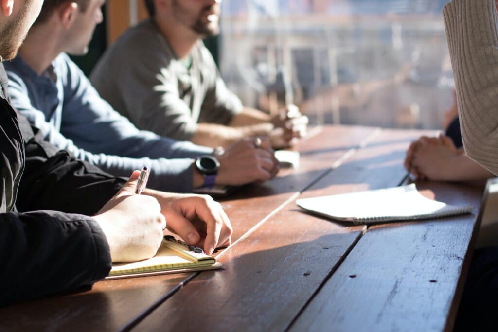 A group of people meeting around a wooden table, representing shareholder disputes in British Columbia