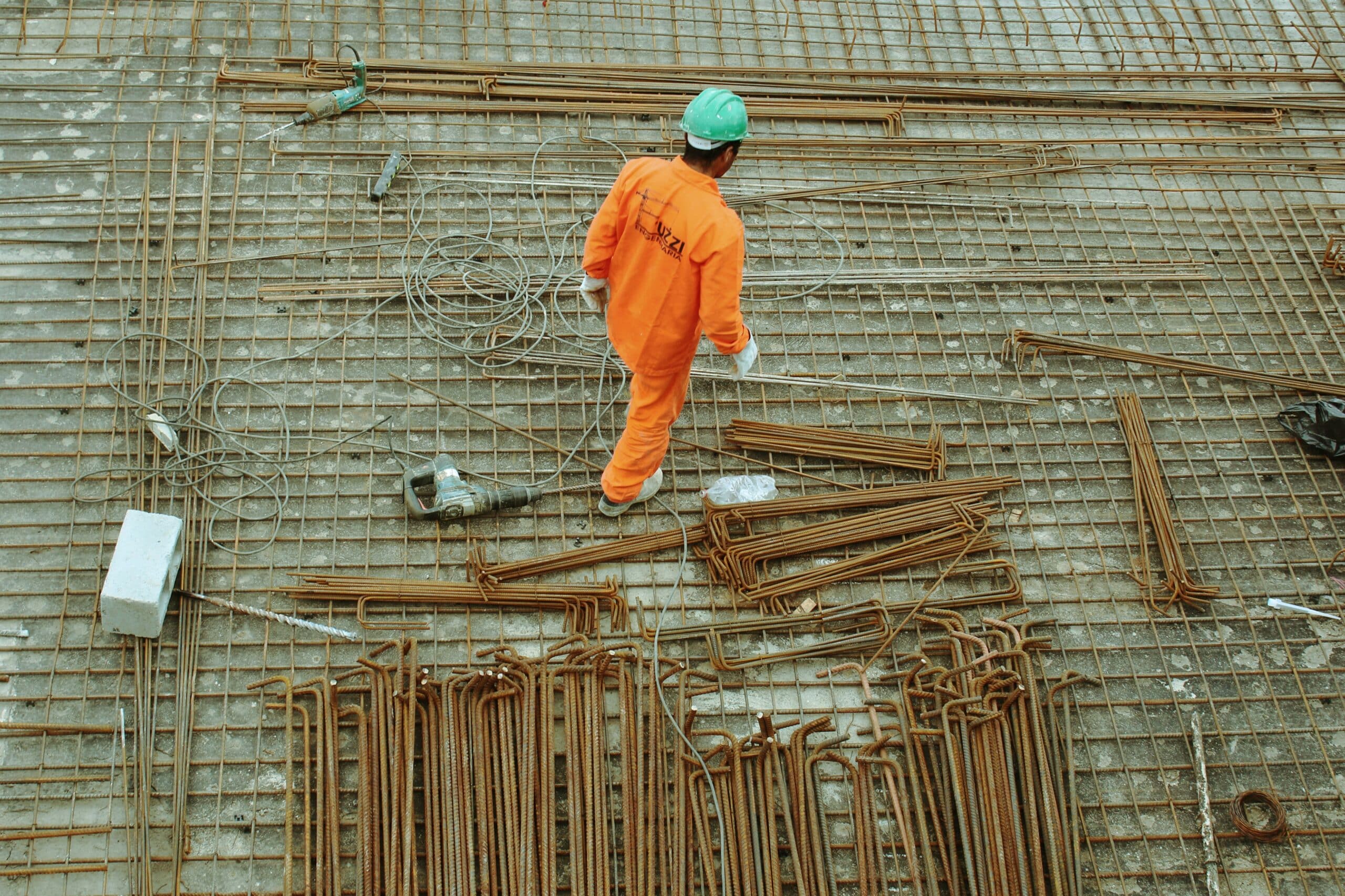 View from above of a construction worker walking across a site strewn with building materials, representing builder's liens in Vancouver