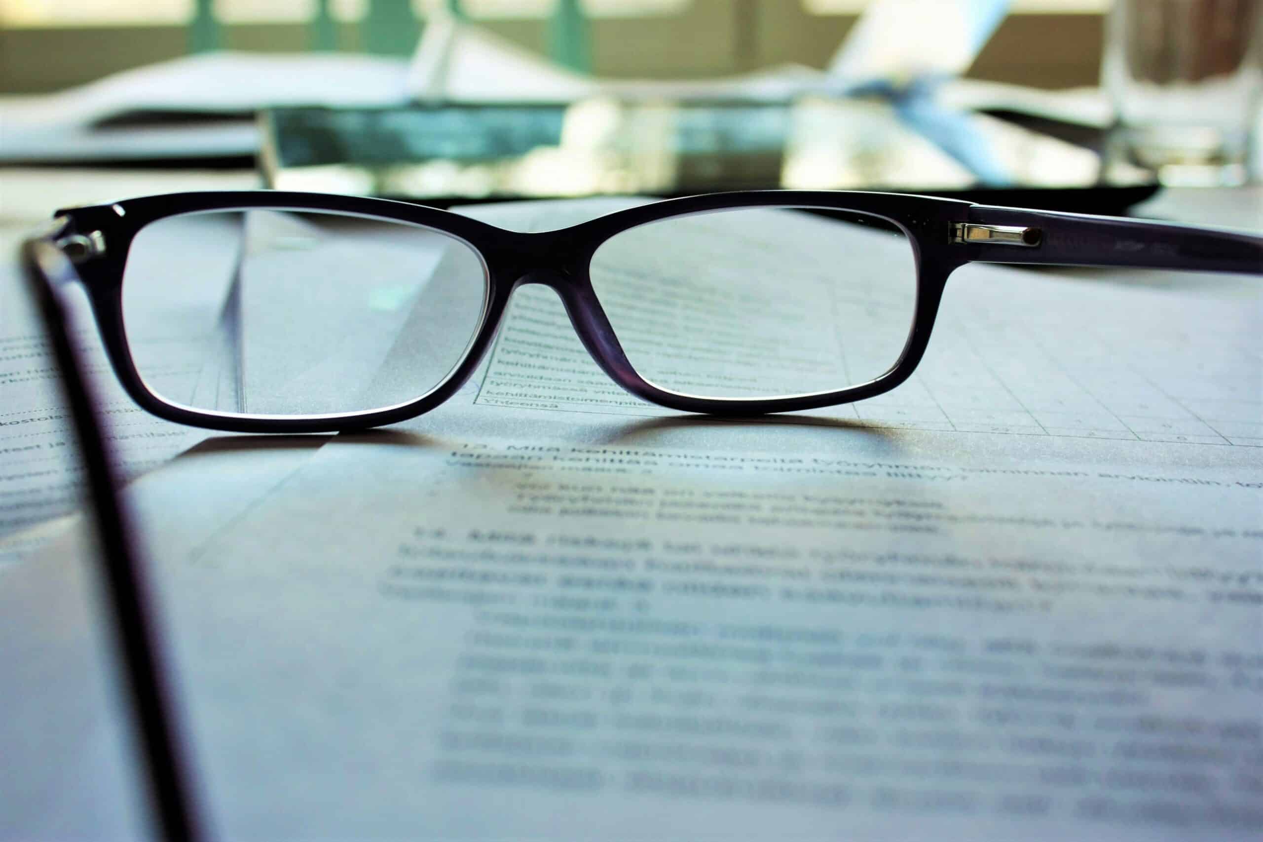 Reading glasses on document representing franchise agreements in British Columbia