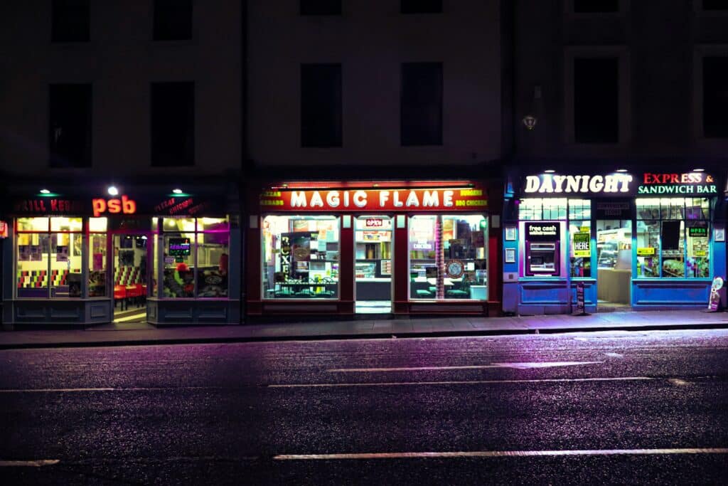 View of a lit-up commercial storefront at night consisting of three restaurants/take outs, representing commercial lease breaches in BC