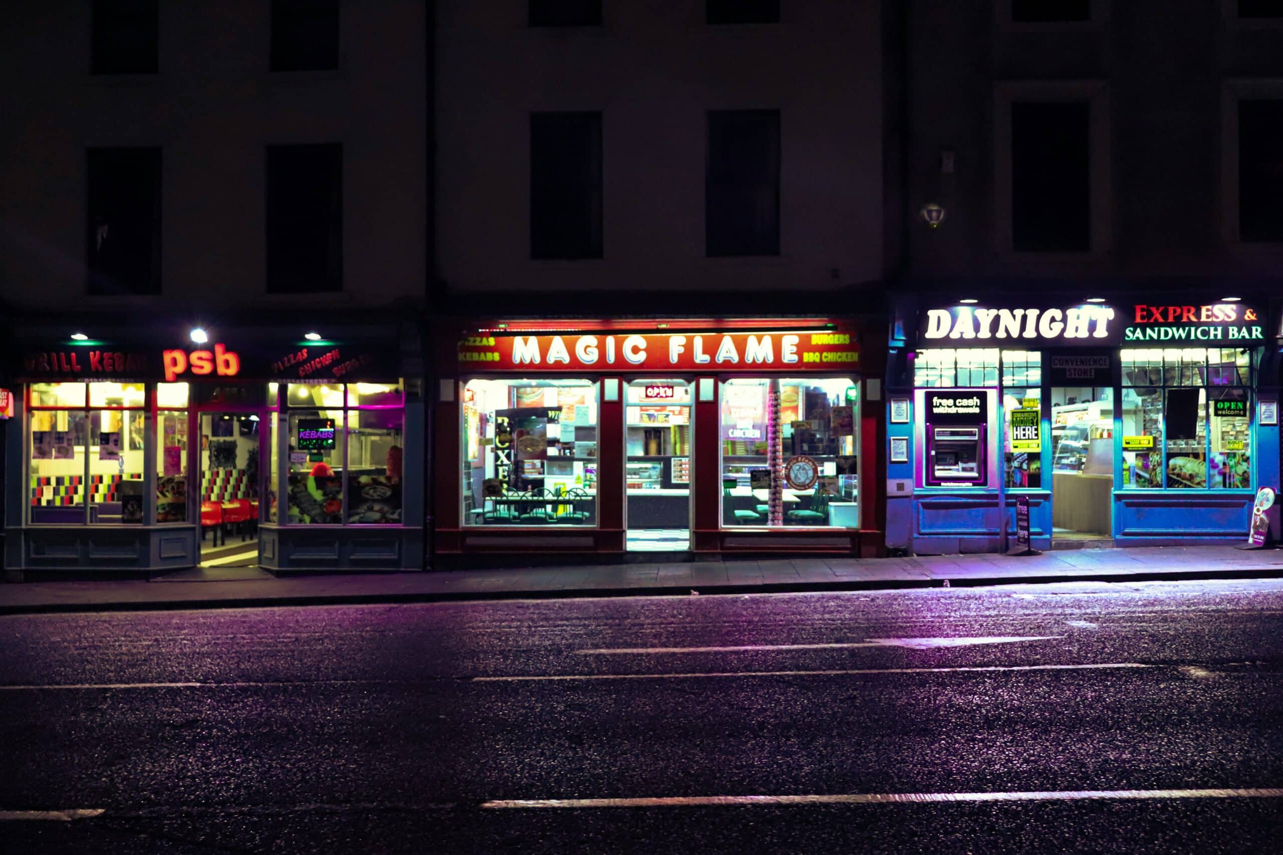 View of a lit-up commercial storefront at night consisting of three restaurants/take outs, representing commercial lease breaches in BC