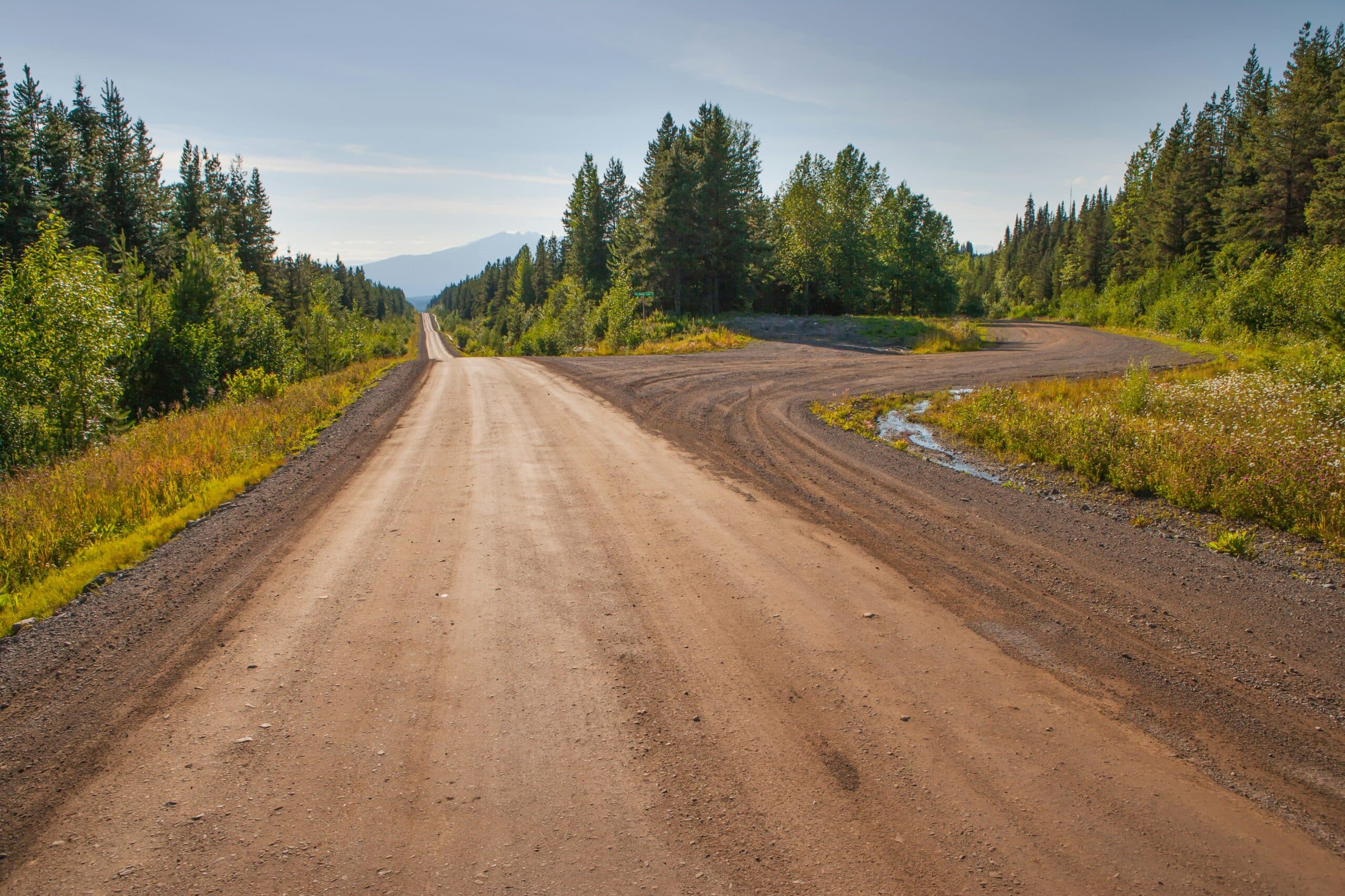Looking down a dirt road winding though the BC countryside, representing purchaser's liens in land deals gone wrong