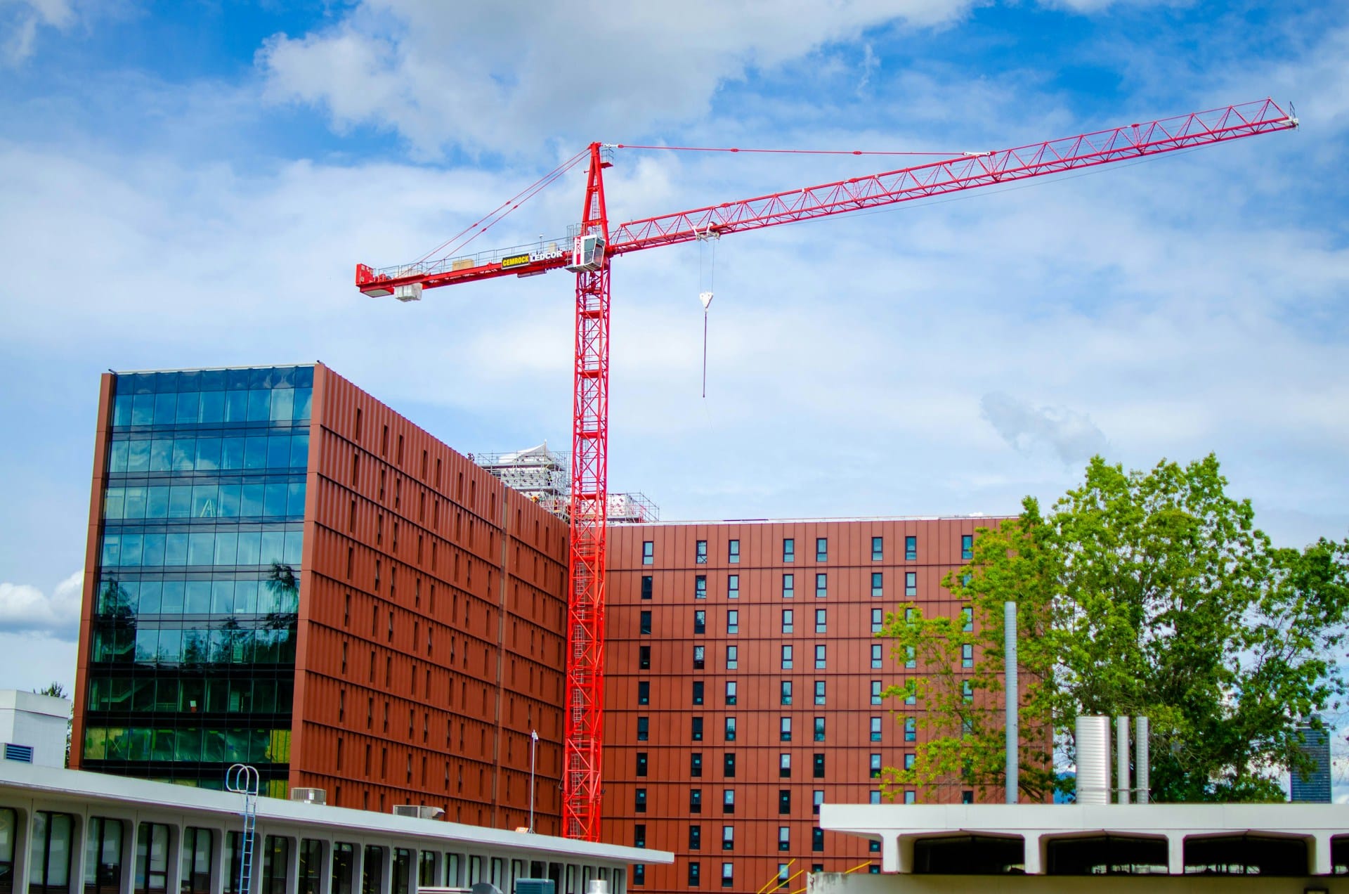 A construction crane in front of a newly-built residential building, representing Builders Lien Act holdback obligations for Vancouver land developers