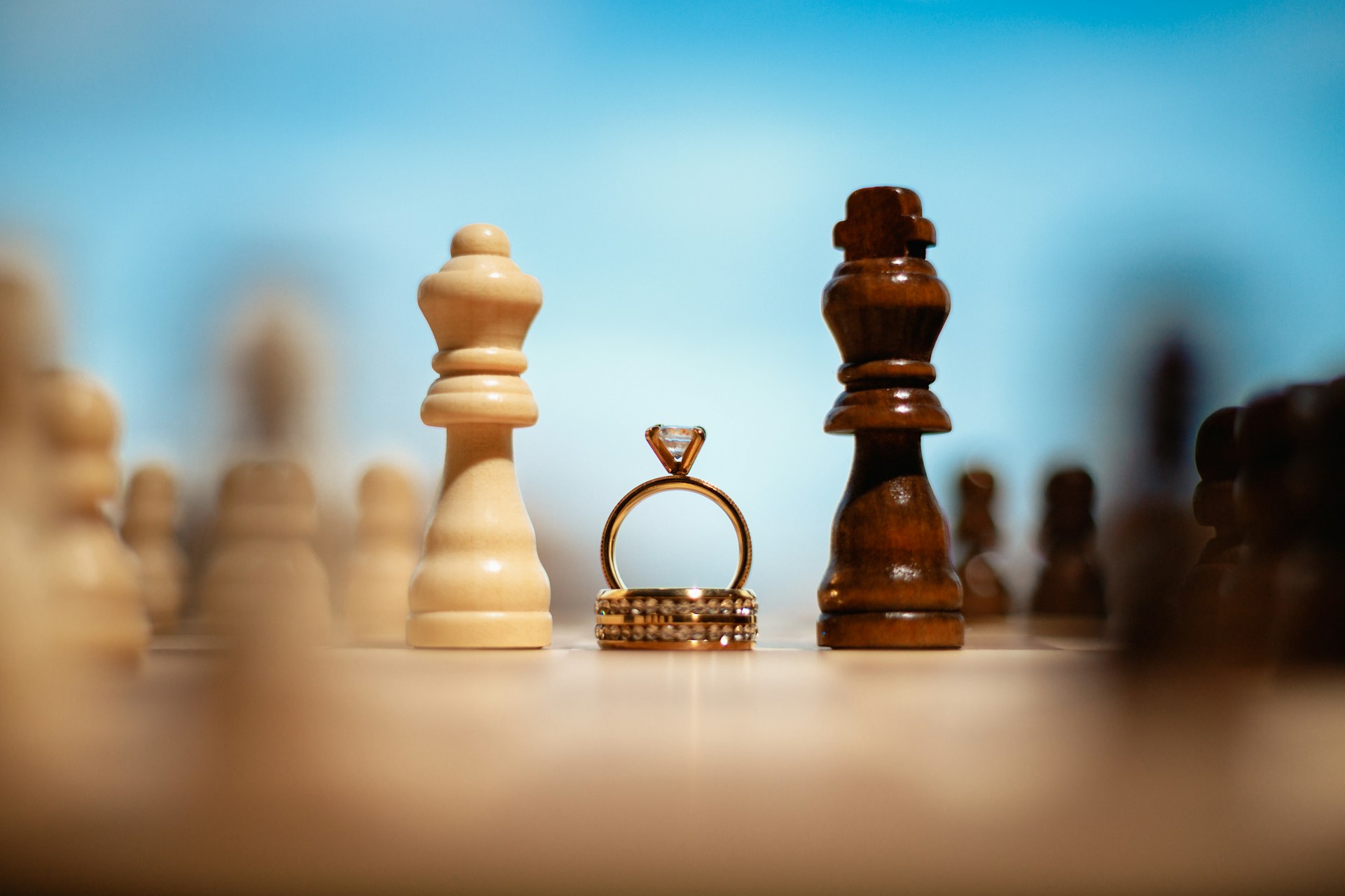 Two chess pieces with a wedding ring positioned in between them, representing separation, divorce, and enforcing mediation agreements in complex property division disputes in BC family law