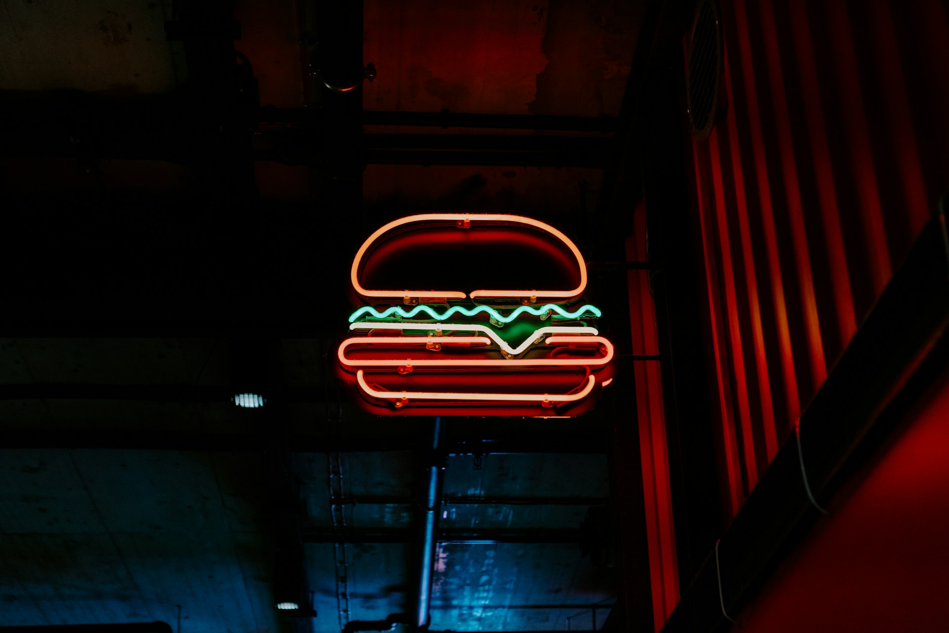 A neon burger affixed to the side of a building, representing commercial rental properties and breaking commercial leases, leading to landlord-tenant disputes in BC.