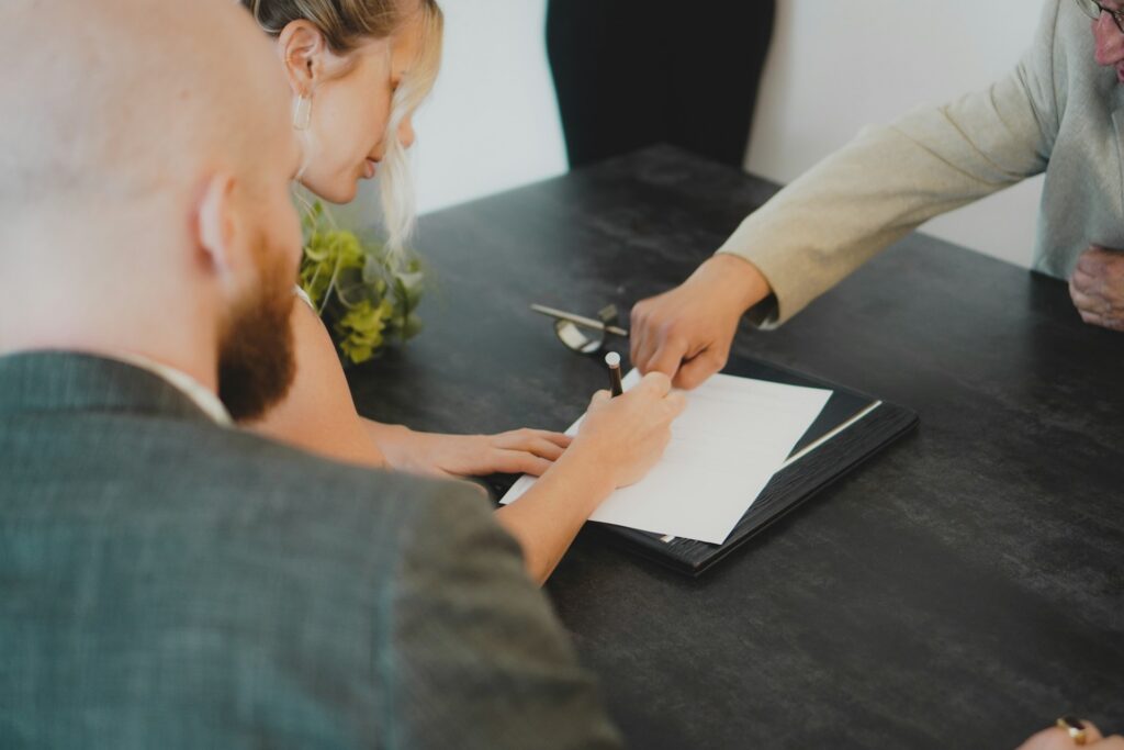 A woman and a man signing a commercial litigation release, representing the SCC's decision in Corner Brook v. Bailey.